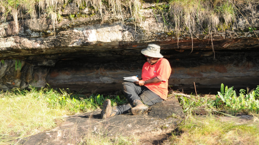 Photo of speaker, Catherine Namono, on a rock during her research