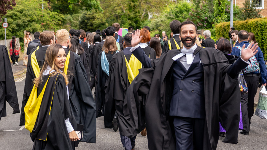 Two students attending the graduation from Wolfson College look at the camera