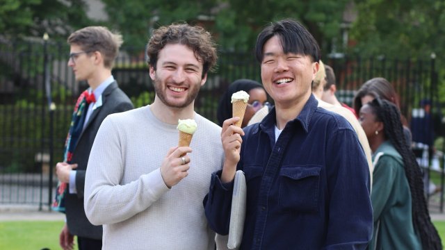 Two male students enjoy free ice creams on the front court